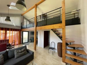 a loft apartment with a staircase and a living room at Maison Milla in Saint-Égrève