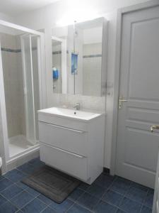 een witte badkamer met een wastafel en een douche bij Nice Appt In Briançon Les Charmettes in Briançon
