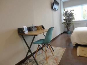 biurko z zielonym krzesłem w sypialni w obiekcie La Ruta de las luces de Vigo w mieście Vigo