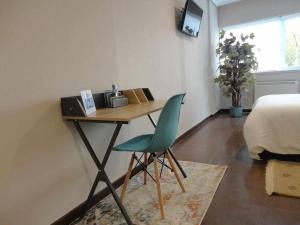 1 dormitorio con escritorio y silla verde en La Ruta de las luces de Vigo, en Vigo