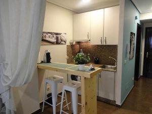 a kitchen with a counter and stools in it at La Ruta de las luces de Vigo in Vigo