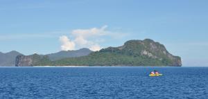 Un par de personas en un bote en un cuerpo de agua en Neela Tourist Lodge, en El Nido