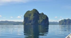 a boat in the water with mountains in the background at Neela Tourist Lodge in El Nido +17 photos