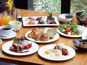 a table with plates of breakfast food on it at Hotel Agora Osaka Moriguchi in Osaka