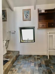 a bathroom with a toilet and a window at Ollava Guesthouse in Simonʼs Town +67 photos