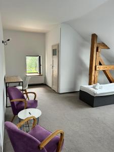 Pokój z fioletowymi krzesłami i łóżkiem w obiekcie Folwark Matecznik - Dworek w mieście Sęzinko