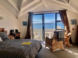 a bedroom with a bed and a view of the ocean at Ollava Guesthouse in Simonʼs Town