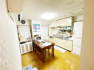 eine Küche mit weißen Schränken und einem Holztisch in der Unterkunft Reinahill - Vacation STAY 67181v in Tokushima