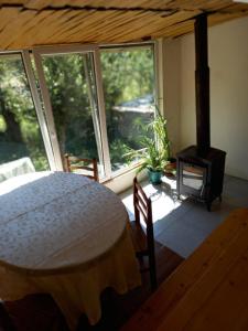 a bedroom with a bed and a fireplace and windows at Dali Kaldanis Guest House in Becho in Mestia