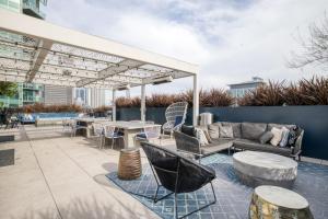 a patio with couches and tables and a pergola at Downtown 1BR w Pool Gym nr Staples Center LAX-624 in Los Angeles