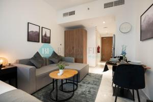 a living room with a couch and a table at Modern Studio In Oasis in Al Qurayyah