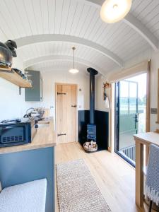 a kitchen and living room with a stove at The Black Swan Shepherd Hut in Ketton