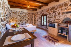 a room with a bed and a table with a bowl of fruit on it at Plagia Rooms in Kissamos