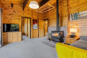 a living room with a fireplace and a stove at Hanmer Hideaway in Hanmer Springs