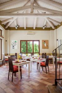 - une salle à manger avec des tables, des chaises et des fenêtres dans l'établissement Relais Montemarino, à Borgomale
