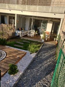 a backyard with a wooden deck and a swing at Appart' cocooning prêt de la forêt in Seignosse