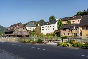 a village with a wooden barn and a road at NaturparkResort Haus der Hoamatlegenden in Landl