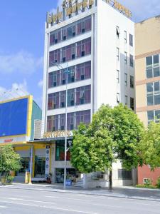 Un edificio alto y blanco en una calle de la ciudad. en Sen Hotel Hạ Long, en Ha Long