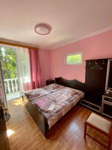 夏克班提維的住宿－Mai Shekvetili，卧室配有一张床铺,位于一间粉红色墙壁的房间