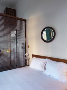 1 dormitorio con 1 cama con espejo en la pared en Talpiot Oasis-Louis en Haifa