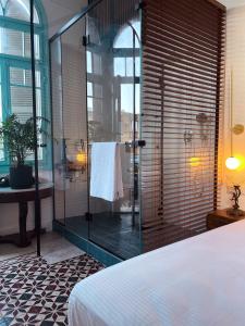 La salle de bains est pourvue d'une douche en verre avec un lit et un lavabo. dans l'établissement Talpiot Oasis-Louis, à Haïfa