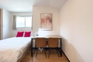 una camera con un letto e due sedie di Elegant House a Tokyo
