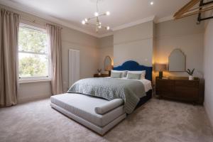 una camera da letto con un letto, un comò e uno specchio di Our House Collective - Luxury Stay in Lincoln City Centre, Hot tub, Sleeps 16 a Lincoln