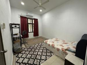 a bedroom with a bed and a window with a fan at Azzahra Homestay Pekan with 3 Bedrooms fully airconditioner in Pekan