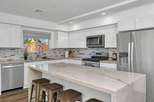 Una cocina blanca con una gran encimera de mármol. en Wonderful 3 Bedroom Home Perfect for Getaway, en Los Ángeles 17 fotos más