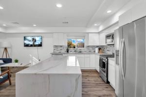 una cocina blanca con una gran encimera blanca en Wonderful 3 Bedroom Home Perfect for Getaway, en Los Ángeles