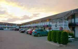 a parking lot with cars parked in front of a building at Grama's Inn in Prince George