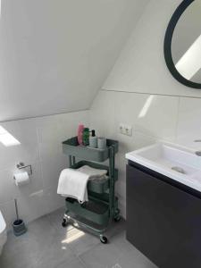 ein Badezimmer mit einem Waschbecken und einem Regal mit Handtüchern in der Unterkunft Messe- Augsburg- Legoland Günzburg - 6 Personen in Zusmarshausen