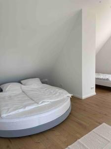 een ongemaakt bed in een kamer met een witte muur bij Messe- Augsburg- Legoland Günzburg - 6 Personen in Zusmarshausen