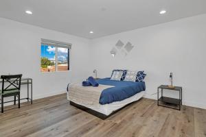 Schlafzimmer mit einem Bett, einem Tisch und einem Fenster in der Unterkunft Modern 3BR Home in Mid-City in Los Angeles