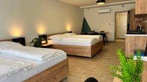 1 dormitorio con 2 camas y mesa en Rezidex Apartmanház en Szeged
