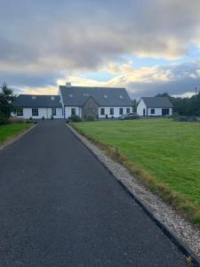 eine Straße, die zu einem großen weißen Haus führt in der Unterkunft Connemara Ocean Escape in Galway