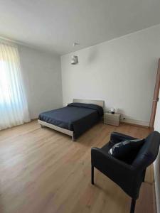 a bedroom with a bed and a chair and a couch at Appartamento Casa Armonia a Montefiascone in Montefiascone
