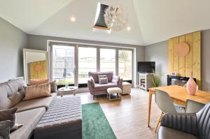 a living room with a couch and a table at Stylish Family Home by Twickenham Stadium by UnderTheDoormat in London