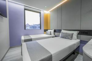 Hotel 81 Palace - NEWLY RENOVATED في سنغافورة: سريرين في غرفة مع نافذة
