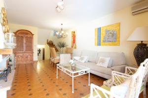 uma sala de estar com um sofá e uma mesa em Global Properties, Adosado con piscina en la playa de Canet em Canet d'En Berenguer
