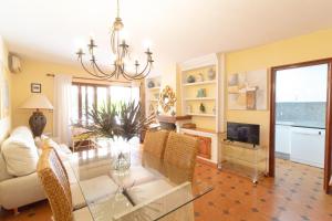 uma sala de estar com uma mesa, um sofá e uma televisão em Global Properties, Adosado con piscina en la playa de Canet em Canet d'En Berenguer