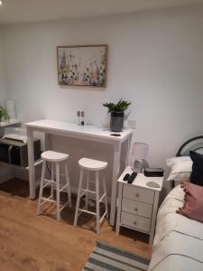 a room with a table and stools in a room at The Annex in Briston