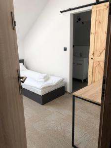 1 dormitorio con 1 cama y puerta abierta en Folwark Matecznik - Spichlerz, en Sęzinko