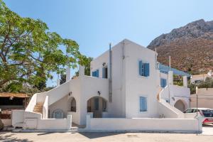 una casa blanca con una montaña en el fondo en Giannis apartment, en Kalymnos