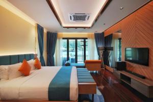 a hotel room with a bed and a television at Gayana Marine Resort in Gaya Island