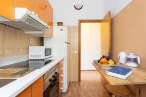 uma cozinha com um frigorífico branco e uma mesa com frutas em Home2Book Cozy Apartment Santa Cruz City Center em Santa Cruz de Tenerife