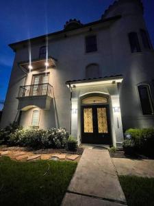 a large white house with a door and a balcony at BAIZA mini castle in the Galleria in Houston