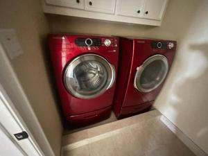 a washing machine and a dryer in a laundry room at BAIZA mini castle in the Galleria in Houston