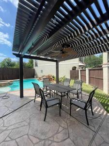 a patio with a table and chairs next to a pool at BAIZA mini castle in the Galleria in Houston