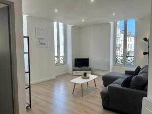 una sala de estar con un sofá y una mesa en L'AUTHENTIQUE - Moderne - Central, en Mont-de-Marsan
